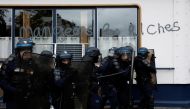 French CRS riot police secure a position during a demonstration in Paris as part of a nationwide day of strike and protests for higher wages and against requisitions at refineries in France, on October 18, 2022. The slogan reads 