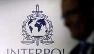 A man passes an Interpol logo during the handing over ceremony of the new premises for Interpol's Global Complex for Innovation, a research and development facility, in Singapore, on September 30, 2014.  File Photo / Reuters