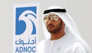 An Emirati man is seen near the logo of ADNOC in Ruwais, United Arab Emirates, on May 14, 2018. Picture taken May 14, 2018. File Photo / Reuters

