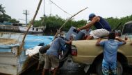 Fishermen upload an outboard motor to a pickup as Hurricane Roslyn approaches tourist zones along Mexico's Pacific coast, in San Blas in Nayarit state, Mexico, on October 22, 2022. REUTERS/Hugo Cervantes
