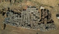 A Palestinian worker walks near broken batteries collected for sale and export, in Gaza Strip October 16, 2022. Reuters/Mohammed Salem
 