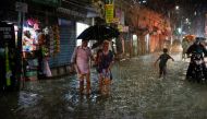 People wade through a flooded street amid continuous rain before the Cyclone Sitrang hits the country in Dhaka, Bangladesh, October 24, 2022. REUTERS .