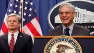 US Attorney General Merrick Garland, with Federal Bureau of Investigation (FBI) Director Christopher Wray, reacts to a reporter's question after announcing charges against two Chinese nationals for trying to obstruct the prosecution of China's Huawei Technologies Co Ltd, and four others with trying to spy for Beijing, at the Justice Department in Washington on October 24, 2022. REUTERS/Jonathan Ernst