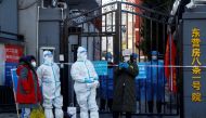 Security personnel in protective suits stand at the gate of a residential compound that is under lockdown as outbreaks of coronavirus disease (COVID-19) continue in Beijing, October 22, 2022. REUTERS/Thomas Peter/File Photo