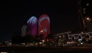 A building in Doha lit up with Qatar and Turkiye flags. 