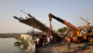 People remove debris after a suspension bridge collapsed in Morbi town in the western state of Gujarat, India, on October 31, 2022. REUTERS/Stringer 