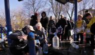 Kyiv residents fill plastic containers and bottles at a water pump in one of the parks in the Ukrainian capital Kyiv on October 31, 2022. - Ukraine suffered sweeping blackouts and water supplies were cut for 80 percent of Kyiv residents on October 31, 2022, after what Ukrainian officials called another 