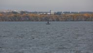 A fisherman stands in a boat on the Dnipro river near the town of Nova Kakhovka, Russian-controlled Ukraine, October 30, 2022. (REUTERS/Alexander Ermochenko)