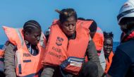 This photo taken on November 3, 2022 and handout on November 5, 2022 by German-flagged NGO Mission Lifeline shows migrants preparing to get on board the 