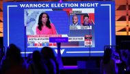 Political news is seen on a screen during the Election night party for Democratic Senate Candidate Raphael Warnock (D-GA) at Atlanta Marriott Marquis on November 08, 2022 in Atlanta, Georgia. Sen. Warnock is in a very tight race with Republican challenger Herschel Walker. If neither candidate receives 50 percent plus one vote needed, they will head to a runoff in December. Michael M. Santiago/Getty Images/AFP
 