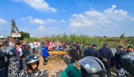 People gather near Egyptian emergency service personnel during the search for survivors after a minibus fell into a canal in al-Dayris village near the Nile Delta city of Mansoura in the Dakahlia Governorate, some 120Km north of the capital, on November 12, 2022. (Photo by Khaled DESOUKI / AFP)