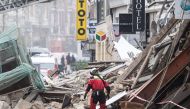 Firefighters inspect a collapsed building as they search for victims in the city of Lille, northern France, on November 12, 2022. (Photo by Sameer Al-DOUMY / AFP)