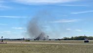 This image obtaimned from the twitter account @GollyItsMollie, shows smoke rising from the crash after two planes collided mid-air during the Wings Over Dallas Airshow at Dallas Executive Airport, in Dallas, Texas, on November 12, 2022. (Photo by Handout / @GollyItsMollie / AFP)