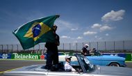 Mercedes' British driver Lewis Hamilton waves a Brazilian national flag during the drivers' parade ahead of the Formula One Brazil Grand Prix at Jose Carlos Pace racetrack, also known as Interlagos, in Sao Paulo, on November 13, 2022. (Photo by MAURO PIMENTEL / AFP)