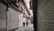 People pass shops which were closed following the recent riots and the call of protesters to close the markets, in Tehran Bazaar, in Tehran, Iran November 16, 2022. WANA (West Asia News Agency) via REUTERS