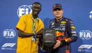 Red Bull's Dutch driver Max Verstappen (right) receives the Pole Position Award after the qualifying session on the eve of the Abu Dhabi Formula One Grand Prix at the Yas Marina Circuit in the Emirati city of Abu Dhabi on November 19, 2022. (Photo by Kamran JEBREILI / POOL / AFP)