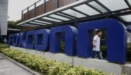 A man walks past a company logo at the entrance to a Foxconn factory in the township of Longhua in the southern Guangdong province May 27, 2010. File Photo / Reuters
