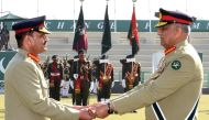 In this handout photograph taken and released by Pakistan's Inter Services Public Relations (ISPR) on November 29, 2022, Pakistan's new Army Chief General Syed Asim Munir (left) receives the change of command baton from outgoing army chief General Qamar Javed Bajwa (right) during the change of command ceremony in Rawalpindi. (Photo by Pakistan's Inter Services Public Relations (ISPR) / AFP)
