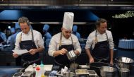 In this photograph taken on December 1, 2022 Spanish twin chefs, Javier (R) and Sergio (L) Torres prepare some meals in the kitchen of their restaurant 'Cocina Hermanos Torres' after receiving the distinction of three-stars from the Michelin guide, in Barcelona. Photo by Josep LAGO / AFP