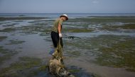 In this file photo taken on August 28, 2022 Scientist Ivan Roussev Ivan Rusev pulls a dead dolphin in the Limans Tuzly Lagoons National Nature Park, near the village of Prymorske amid the Russian invasion of Ukraine. (Photo by Dimitar Dilkoff / AFP)