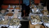 A vendor waits for customers as price tags are seen on the fish baskets at a vegetable market, amid the country's economic crisis in Colombo, Sri Lanka, May 20, 2022. (REUTERS/Adnan Abidi)
