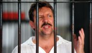 In this file photo taken on April 9, 2008 Russian arms dealer Viktor Bout speaks to the press from behind his cell bars of the criminal court detention center in Bangkok. (Photo by Saeed KHAN / AFP)