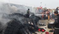 People douse a cargo supply truck after it was hit during the artillery shelling, in the Pakistan-Afghanistan border town of Chaman, Pakistan, on December 11, 2022. REUTERS/Abdul Khaliq Achakzai
