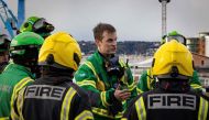 This handout picture obtained on December 11, 2022 from the Government of Jersey shows fire crews speaking next to the rubble of a low-rise apartment building after an explosion, in the Channel island's port capital Saint Helier. (Photo by Government of Jersey. / AFP) 