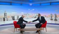 A handout picture released by the BBC, taken and received on December 11, 2022, shows Britain's Foreign Secretary James Cleverly (right) shaking hands with Medical Director of NHS England, Stephen Powis during an appearance on the BBC's 'Sunday Morning' political television show with journalist Laura Kuenssberg at the BBC headquarters in London. (Photo by Jeff OVERS / BBC / AFP)