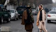 Members of the Taliban security forces walk near a site of an attack at Shahr-e-naw which is city's one of main commercial areas in Kabul on December 12, 2022. (Photo by Wakil KOHSAR / AFP)