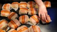 An employee places burgers at the new restaurant 'Vkusno & tochka', which opens following McDonald's Corp company's exit from the Russian market, in Moscow, Russia, June 12, 2022. (REUTERS/Evgenia Novozhenina)