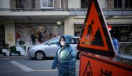 A woman wearing a face mask walks on a street, as coronavirus disease (COVID-19) outbreaks continue in Shanghai, China, December 14, 2022. REUTERS/Aly Song