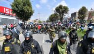 Members of the police escort supporters of former President Pedro Castillo while they march to the center of the city of Arequipa, Peru, demanding the closure of Congress and the release of Castillo, on December 14, 2022.  (Photo by Diego Ramos / AFP)