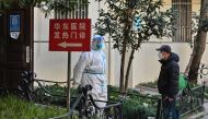 A health worker wearing protective equipment (PPE) stands at the entrance of a fever clinic of a hospital in Shanghai on December 18, 2022. (Photo by HECTOR RETAMAL / AFP)