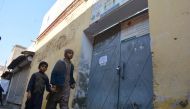 Children walk past a locked school gate after Taliban militants seized a police station in Bannu on December 20, 2022. (Photo by Karim ULLAH / AFP)
 