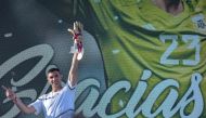 The goalkeeper of the Argentine soccer team Emiliano Martinez, holds gold medal and gold glove trophy awarded by FIFA during a tribute to him, in Mar del Plata, Argentina, on December 22, 2022, upon his return to his hometown after winning the Qatar 2022 World Cup tournament. (Photo by Mara SOSTI / AFP)