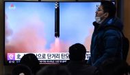 People watch a television screen showing a news broadcast with file footage of a North Korean missile test, at a railway station in Seoul on December 23, 2022 after North Korea fired two short-range ballistic missiles according to South Korea's military. (Photo by Jung Yeon-je / AFP)