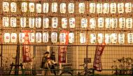 People walk past paper lanterns at a year-end fair in the Nihonbashi district of Tokyo on December 26, 2022. (Photo by Yuichi YAMAZAKI / AFP)