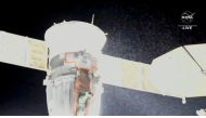 A stream of particles, which NASA says appears to be liquid and possibly coolant, sprays out of the Soyuz spacecraft on the International Space Station, forcing a delay of a routine planned spacewalk by two Russian cosmonauts on December 14, 2022 in this still image taken from video. NASA TV/Handout via REUTERS/File Photo