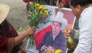 Peruvian shamans hold a poster of ousted Peruvian President Pedro Castillo while executing a ritual at the top of a hill over Lima to deliver their predictions for the coming year on December 28, 2022. (Photo by Cris Bouroncle  / AFP)