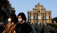 People wearing face masks walk in front of the ruins of Saint Paul's during the coronavirus disease (COVID-19) pandemic in Macau, China, December 29, 2022. REUTERS/Tyrone Siu