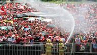 Firefighters spray water to relieve supporters of President-elect Luiz Inacio Lula da Silva from the heat as they gather to wait for his inauguration ceremony at 