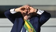 Brazil's new President Luiz Inacio Lula da Silva gestures at supporters making a heart sign with his hands at Planalto Palace after their inauguration ceremony at the National Congress, in Brasilia, on January 1, 2023. (Photo by Evaristo SA / AFP)