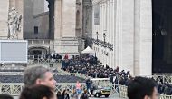People wait in line to pay respect at the body of Pope Emeritus Benedict XVI laying in state in the St. Peter's basilica in the Vatican, on January 2, 2023. (Photo by Andreas Solaro / AFP)