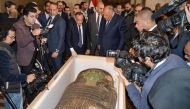 Egypt's Foreign Minister Sameh Shoukry (center right) and the head of the Supreme Council of Antiquities Mostafa Waziri (center left) are surrounded by journalists as they inspect an ancient Egyptian wooden sarcophagus being handed over and which was formerly displayed at Houston Museum of Natural Sciences after having been looted and smuggled years prior, at the foreign ministry headquarters in the capital Cairo on January 2, 2023. (Photo by AFP)
