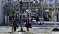 Tunisians are pictured next to a tram station in the capital Tunis' Ariana district, on January 2, 2023, after a strike by the public transport employees was announced the night before. (Photo by FETHI BELAID / AFP)