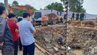 Rescuers look down into the site of where a 10-year-old boy is thought to be trapped in a 35-metre deep shaft at a bridge construction area in Vietnam's Dong Thap province on January 2, 2023. Photo by AFP