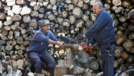 A Palestinian man Samir Hejji and his son cut wood for sale, in Gaza City, December 28, 2022. REUTERS/Ibraheem Abu Mustafa