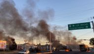 Burning vehicles are seen crossed in the street during an operation to arrest the son of Joaquin 'El Chapo' Guzman, Ovidio Guzman, in Culiacan, Sinaloa state, Mexico, on January 5, 2023. (Photo by Marcos Vizcarra / AFP)