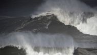 File Photo: A surfer rides a wave in Praia do Norte, Nazare, Portugal, February 25, 2022. (REUTERS/Pedro Nunes)